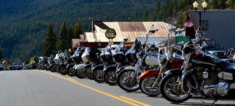 dozens of motorcycles lined up on the side of the road
